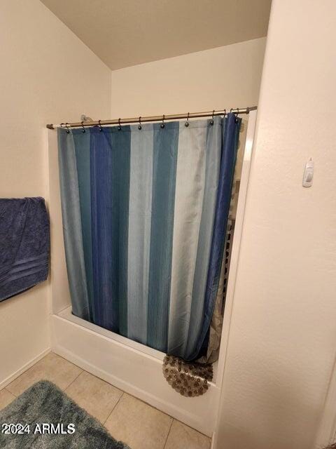 bathroom featuring tile patterned flooring and shower / bathtub combination with curtain