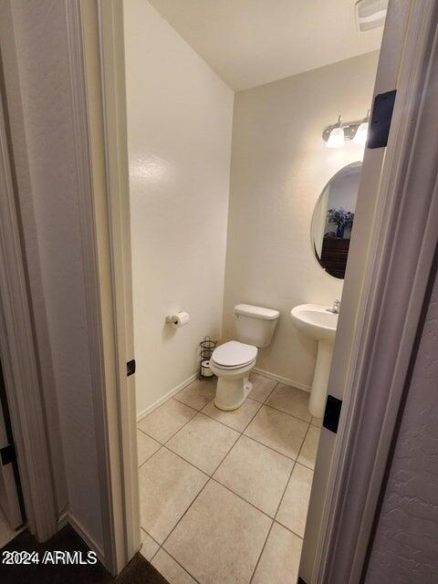 bathroom with toilet and tile patterned floors