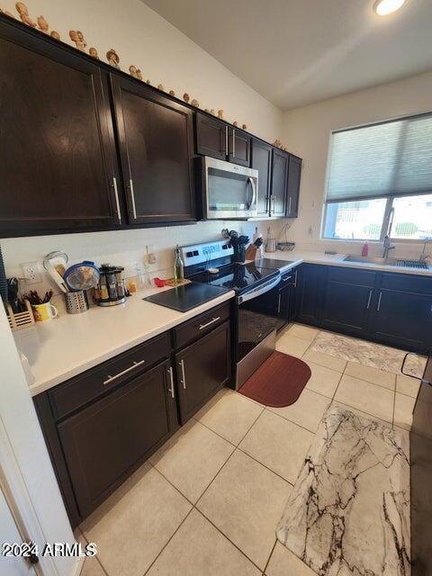 kitchen featuring light tile patterned floors, stainless steel appliances, and sink