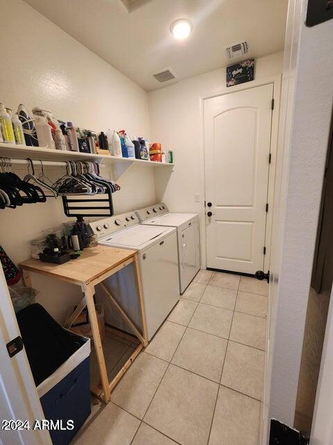 laundry area with light tile patterned floors and independent washer and dryer