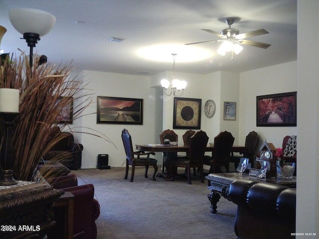 dining area with carpet flooring and ceiling fan with notable chandelier