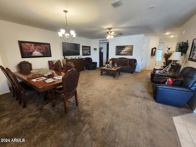 carpeted dining space featuring ceiling fan with notable chandelier