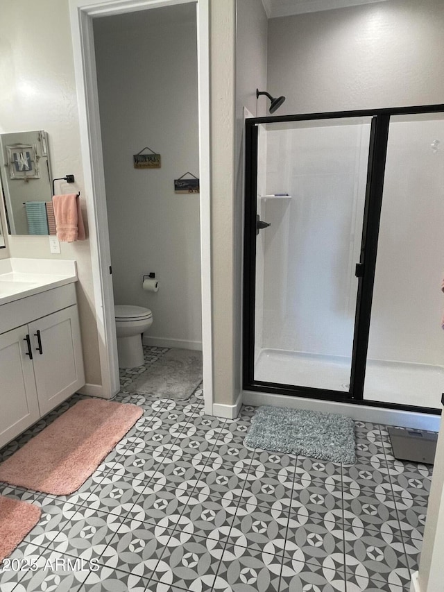 bathroom featuring baseboards, vanity, toilet, and a shower stall