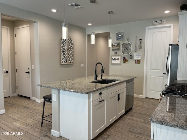kitchen featuring a sink, appliances with stainless steel finishes, light wood-style flooring, and visible vents