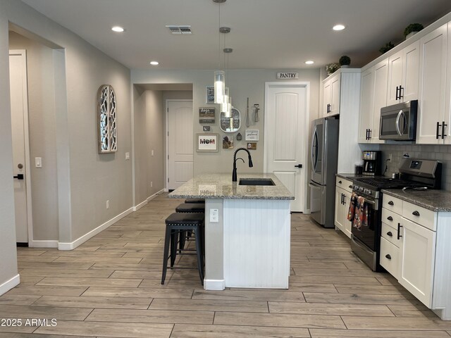 kitchen with a sink, light wood-style floors, stainless steel appliances, recessed lighting, and visible vents