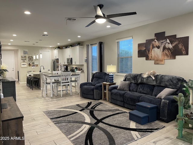 living room with recessed lighting, light wood-style floors, visible vents, and ceiling fan