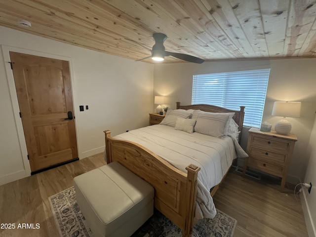 bedroom with a ceiling fan, wood ceiling, baseboards, and light wood finished floors