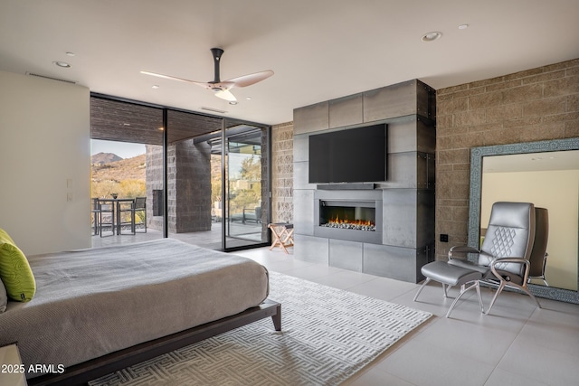 tiled bedroom with expansive windows, access to exterior, and ceiling fan