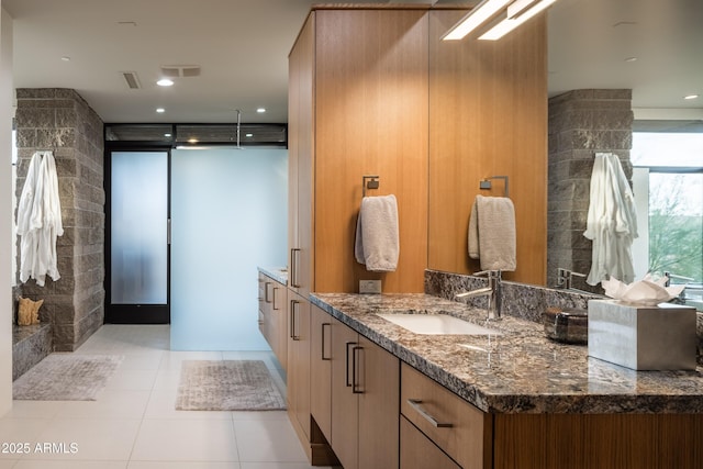 bathroom featuring vanity, tile patterned floors, and walk in shower