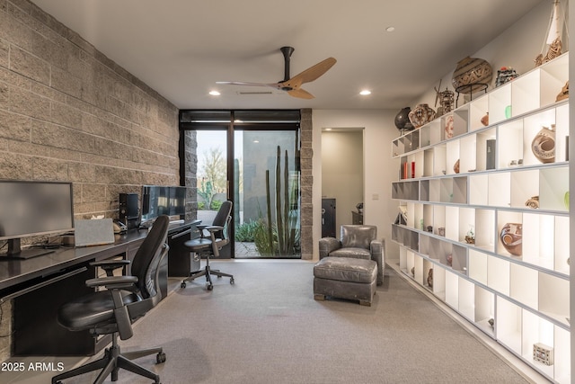 carpeted home office featuring floor to ceiling windows and ceiling fan