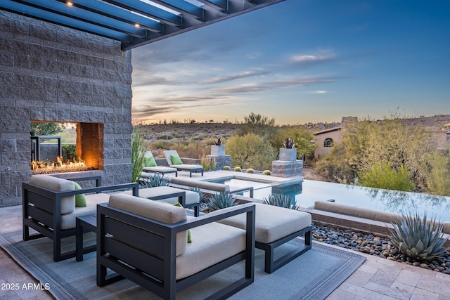 patio terrace at dusk with an outdoor stone fireplace