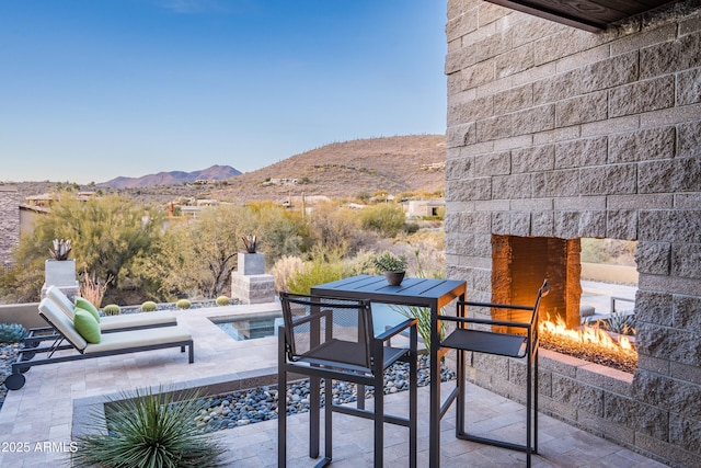 view of patio / terrace featuring a mountain view and an outdoor fireplace