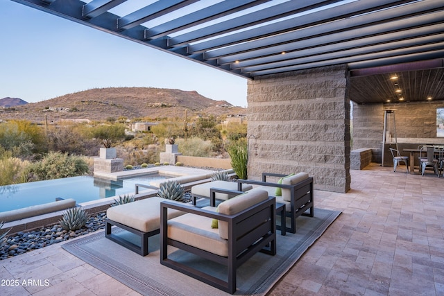 view of patio / terrace featuring a mountain view and an outdoor stone fireplace