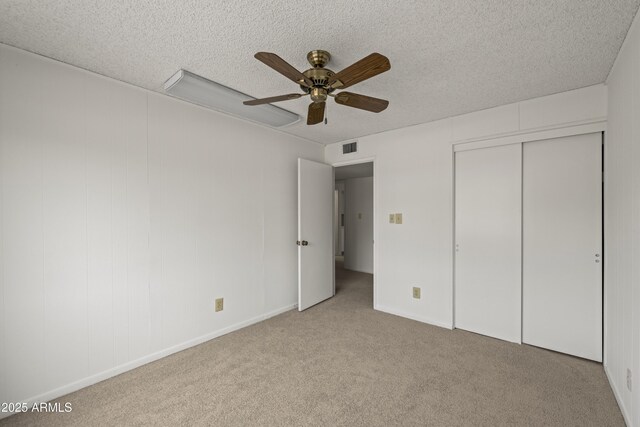 unfurnished bedroom with visible vents, a textured ceiling, a ceiling fan, and carpet floors