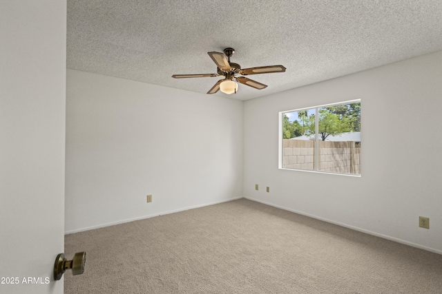 carpeted empty room with baseboards, a textured ceiling, and a ceiling fan