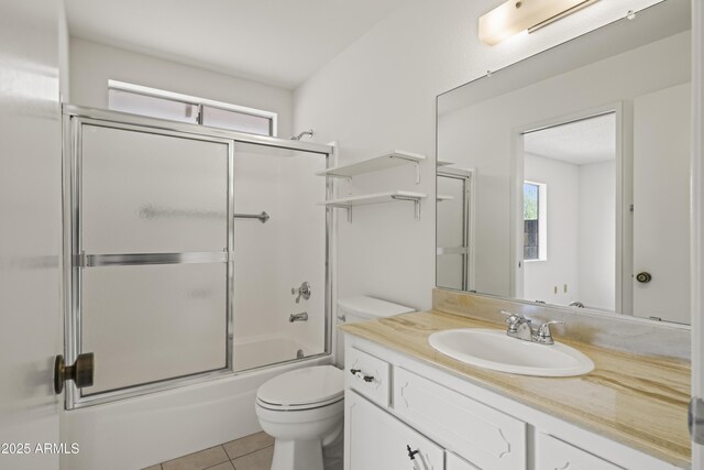 full bathroom featuring tile patterned flooring, toilet, vanity, and bath / shower combo with glass door