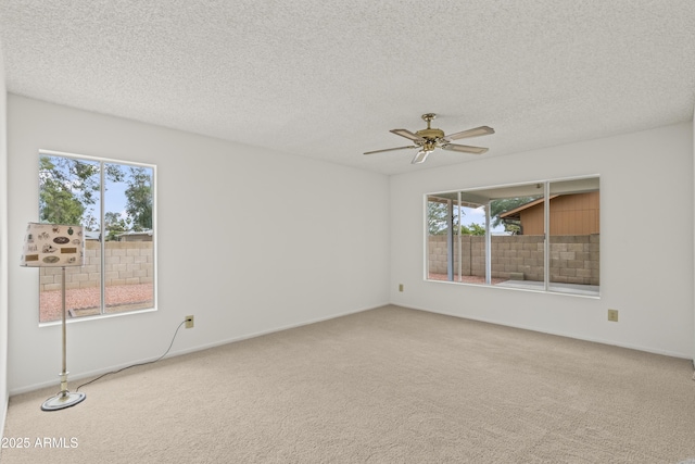 carpeted spare room with baseboards, a textured ceiling, and ceiling fan