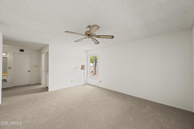 unfurnished room featuring a ceiling fan, baseboards, visible vents, a textured ceiling, and light carpet