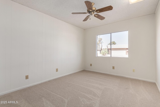 spare room with a ceiling fan, baseboards, a textured ceiling, and carpet flooring