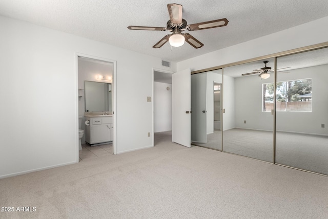 unfurnished bedroom featuring visible vents, carpet, and a textured ceiling