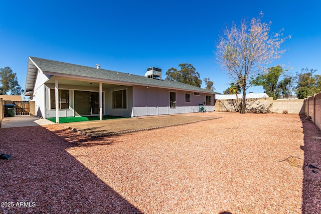 back of house with a patio area, a fenced backyard, and roof with shingles