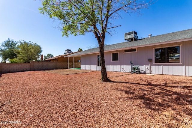 rear view of house with central air condition unit, fence, and a patio area