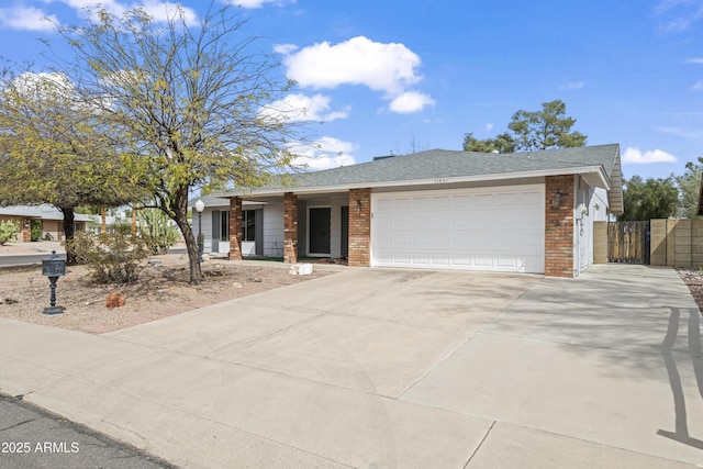 view of front of house featuring fence, driveway, an attached garage, a shingled roof, and brick siding