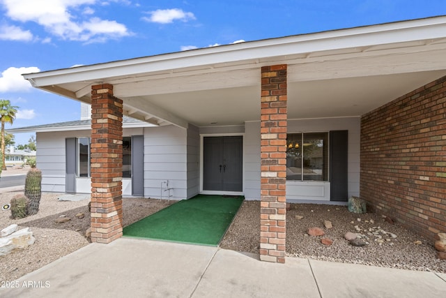 doorway to property with brick siding