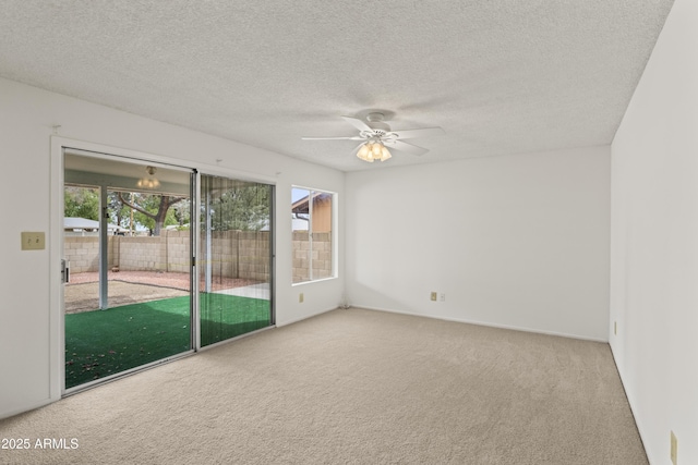 carpeted empty room with a textured ceiling and ceiling fan