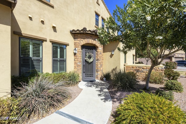 view of exterior entry with stone siding and stucco siding