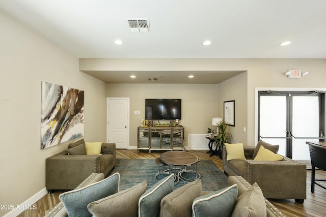 living room with recessed lighting, wood finished floors, and visible vents