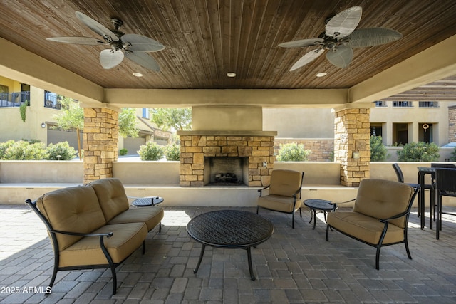 view of patio / terrace featuring a ceiling fan and an outdoor living space with a fireplace