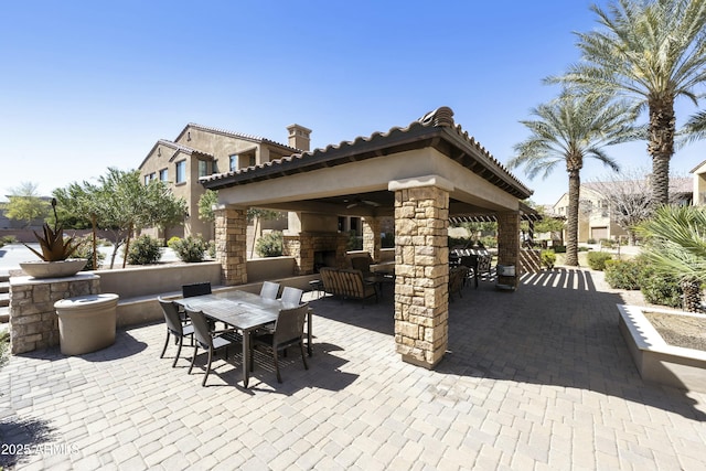 view of patio / terrace with a gazebo, outdoor dining area, and a ceiling fan