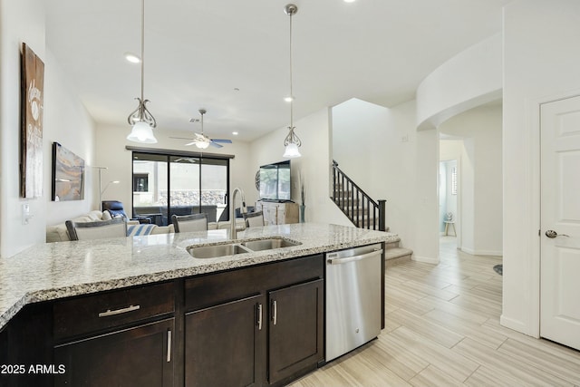 kitchen featuring dark brown cabinets, open floor plan, dishwasher, hanging light fixtures, and a sink