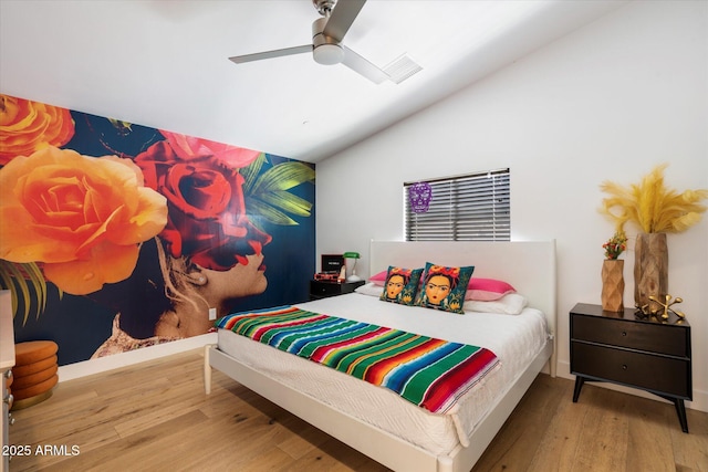 bedroom with ceiling fan, hardwood / wood-style floors, and vaulted ceiling