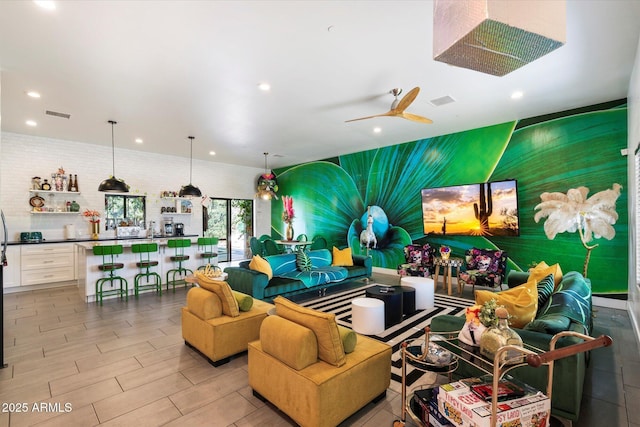 recreation room with ceiling fan and brick wall