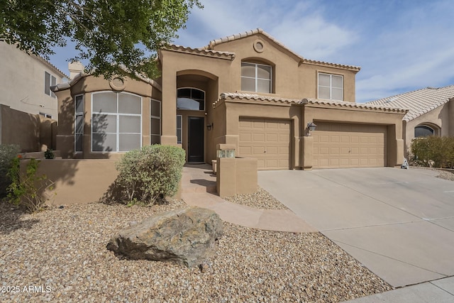 mediterranean / spanish-style house with concrete driveway, a tile roof, an attached garage, and stucco siding