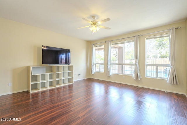 unfurnished living room with ceiling fan, baseboards, and wood finished floors