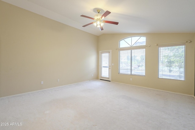 unfurnished room featuring light colored carpet, vaulted ceiling, baseboards, and ceiling fan