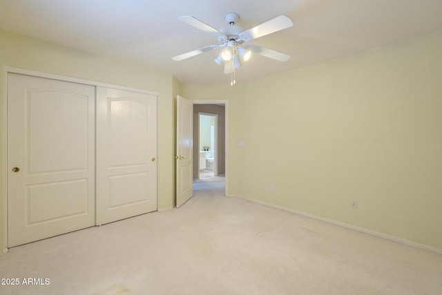unfurnished bedroom with light carpet, a closet, a ceiling fan, and baseboards