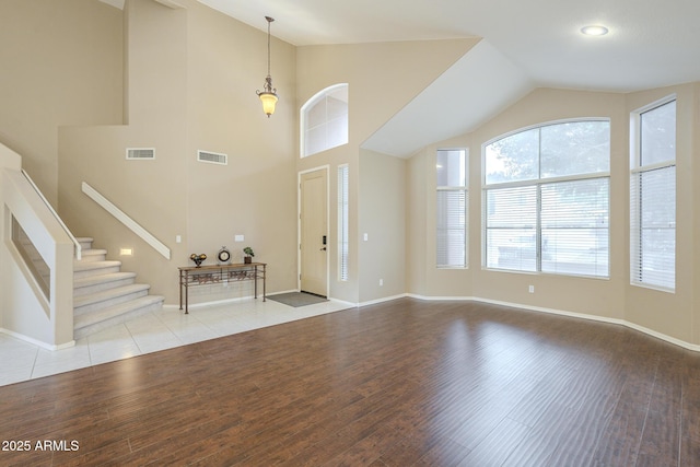 foyer entrance with stairway, baseboards, visible vents, and wood finished floors