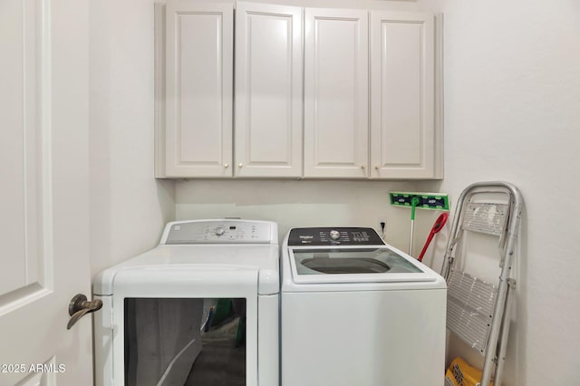 clothes washing area with cabinets and washer and dryer