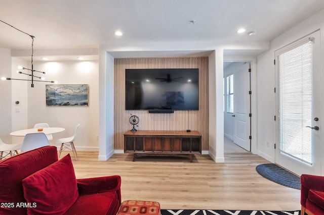 living room with an inviting chandelier and light hardwood / wood-style flooring