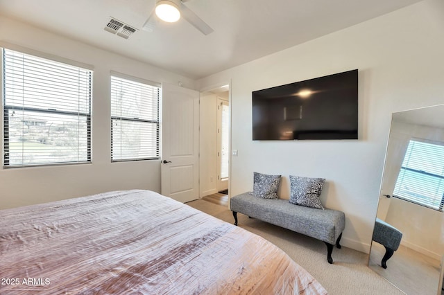 carpeted bedroom with multiple windows and ceiling fan