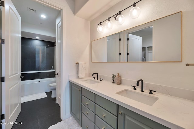 full bathroom featuring tile patterned flooring, vanity, tiled shower / bath combo, and toilet