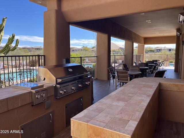 view of patio featuring a fenced in pool, an outdoor kitchen, a grill, and a mountain view