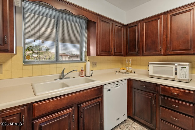 kitchen featuring light countertops, white appliances, a sink, and tasteful backsplash