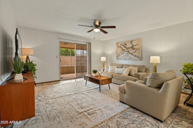 living room featuring a ceiling fan and a textured ceiling