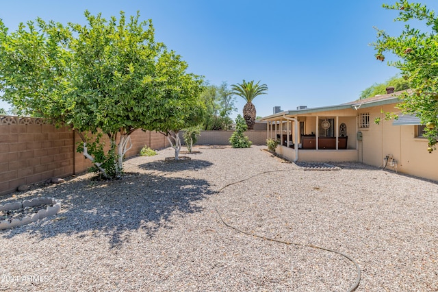 view of yard with a patio area, a fenced backyard, and a sunroom