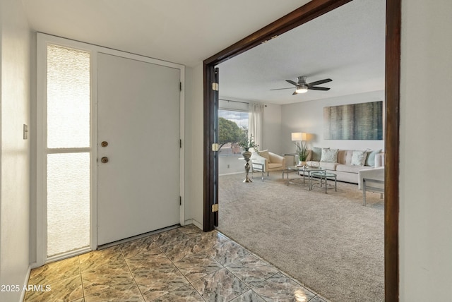 entryway featuring carpet flooring and ceiling fan